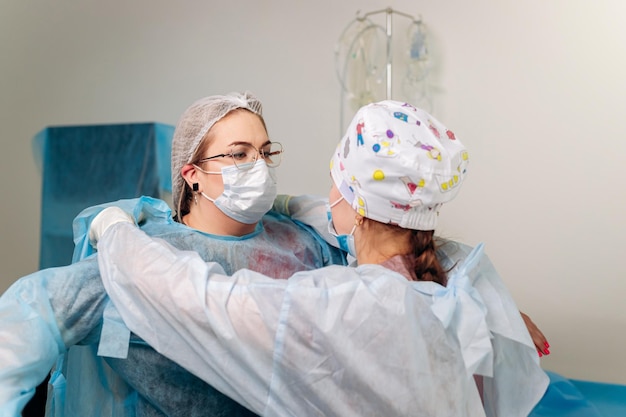 Nurse ties a sterile gown to the surgeon before the operation Doctors prepare for surgery in the operating room put on a medical uniform