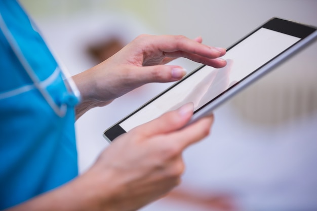 Nurse using digital tablet in hospital ward