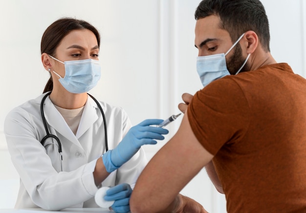 Photo nurse vaccinating young man