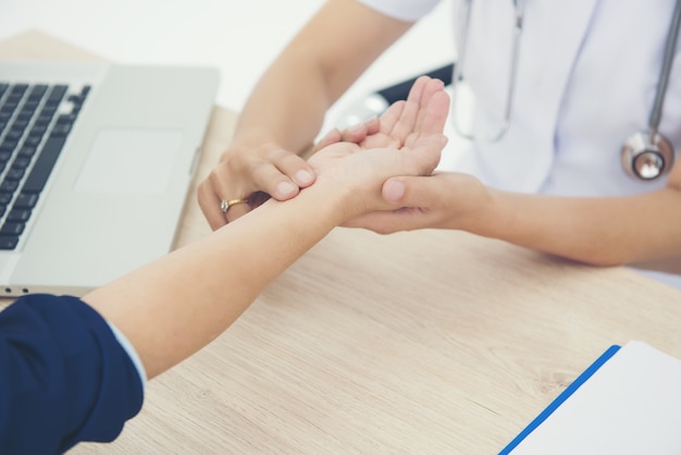 The nurse white uniform checking a patient's pulse 