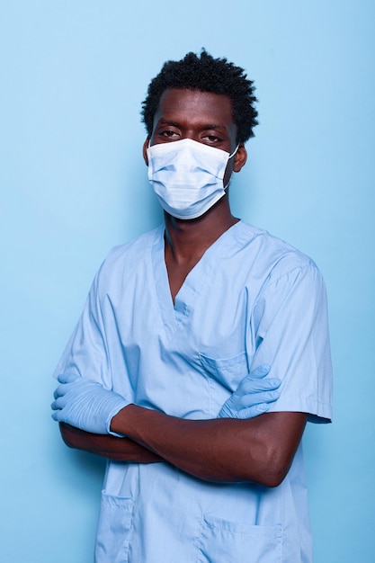 Nurse with crossed arms wearing face mask and gloves