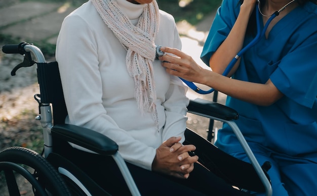 Foto infermiera con un uomo anziano in sedia a rotelle al parco
