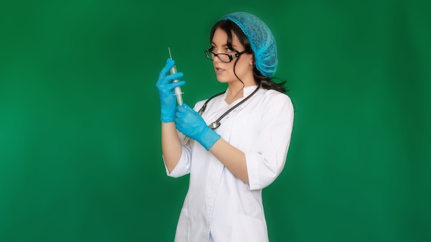 注射器を保持している眼鏡帽子白衣を持つ看護師