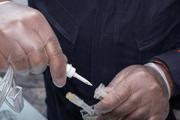 Photo nurse with protective glove connecting the equipment to apply medication to the patient