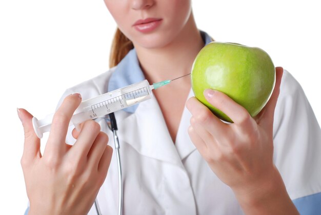 Nurse with syringe make injection in green apple