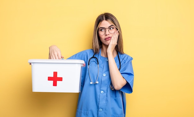 Photo nurse woman feeling bored frustrated and sleepy after a tiresome first aid kit concept