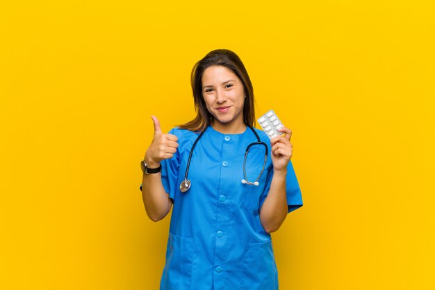 Nurse woman with pils against orange wall