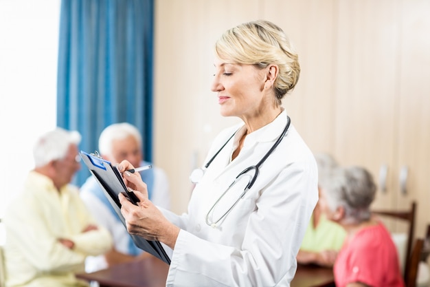 Nurse writing on clipboard