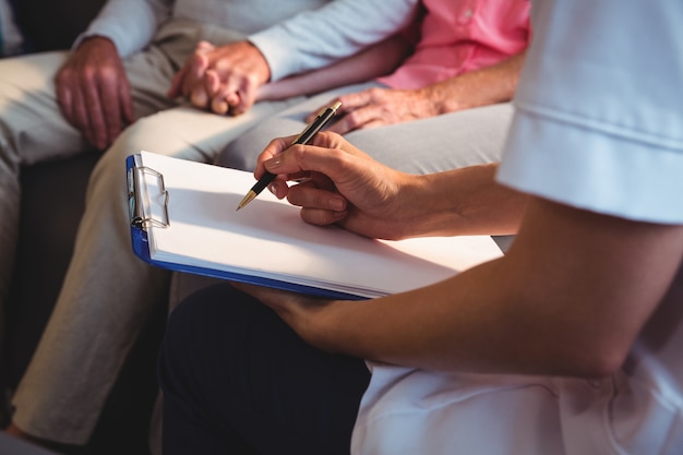 Nurse writing on clipboard