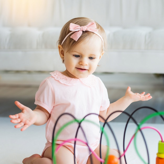 Nursery baby girl playing with educational logic toy