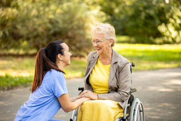 Foto concetto di nursery home buoni rapporti tra l'infermiera e una donna anziana in sedia a rotelle