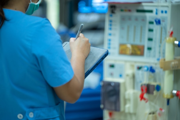 Nurses are checking the function of the hemodialysis machine before use in patients with chronic renal failure.