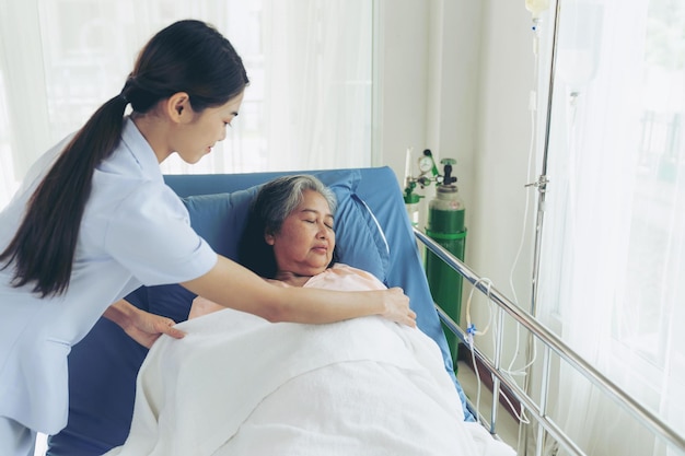 The nurses are well good taken care of elderly woman patients in hospital bed patients feel happiness medical and healthcare concept