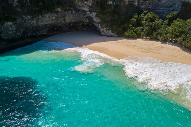 Photo nusa penida island kelingking beach top view aerial view of a sandy clean beach with clear blue and