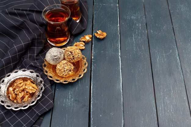 Nut balls dessert served with coffee on dark wooden table, top view