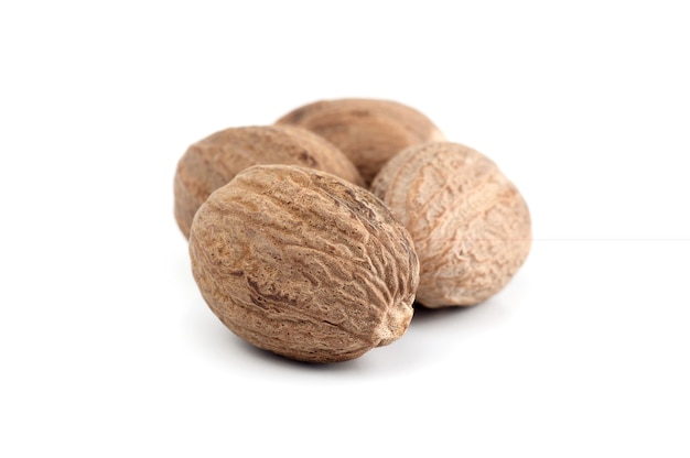 Nutmeg isolated on white surface. Close up.