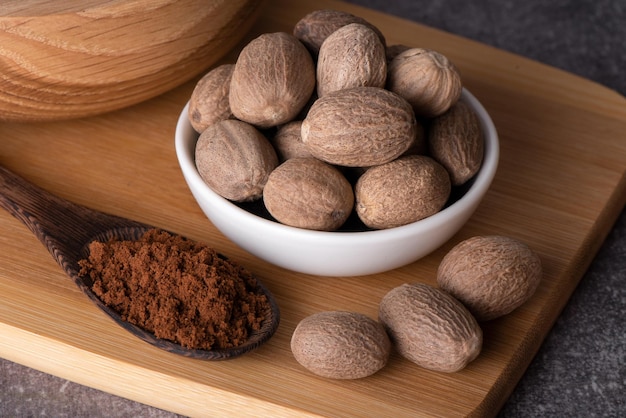 Nutmeg macro in a bowl. Nutmeg powder. Nutmeg spice in a wooden spoon.