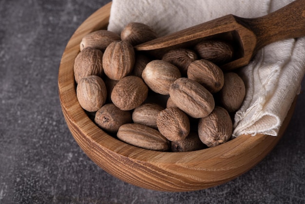 Nutmeg macro in a bowl. Nutmeg powder. Nutmeg spice in a wooden spoon.