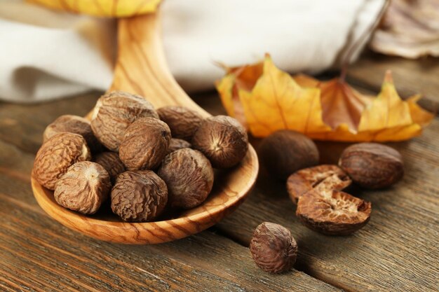 Nutmeg in wooden spoon on table close up