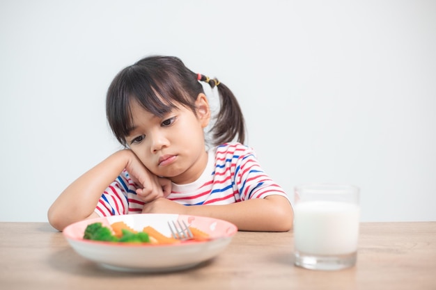 Nutrition healthy eating habits for kids concept Children do not like to eat vegetables Little cute girl refuses to eat healthy vegetables