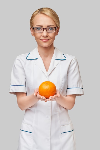 nutritionist doctor healthy lifestyle concept - holding orange fruit