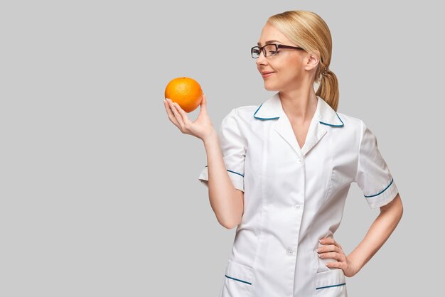 nutritionist doctor healthy lifestyle concept - holding orange fruit