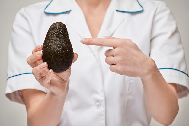 nutritionist doctor healthy lifestyle concept - holding organic avocado fruit