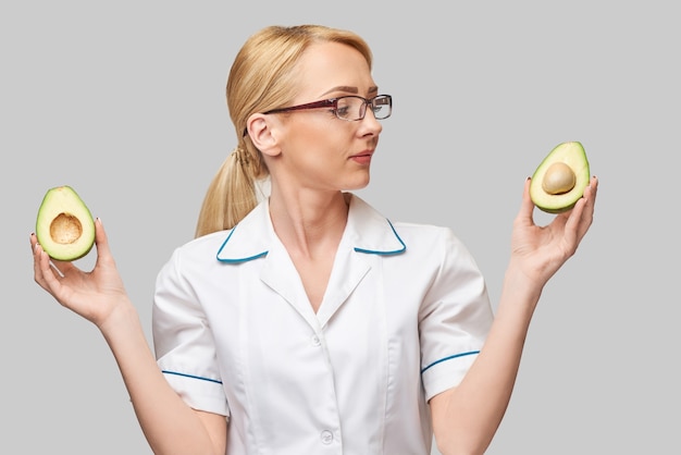 Concetto di stile di vita sano medico nutrizionista - tenendo il frutto di avocado biologico