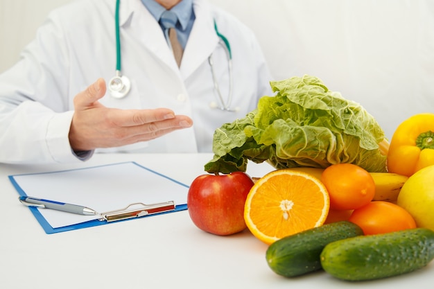 Nutritionist doctor writing diet plan on table