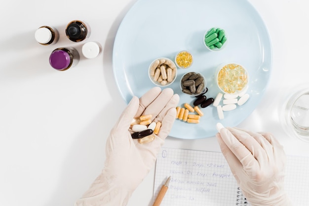 Nutritionist holding biologically active supplements tablets in gloves and help patient to plan daily diet Pills for health care Recommendation for daily dietary