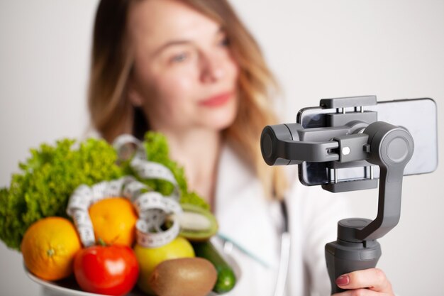 Nutritionist records a video blog about healthy eating on a mobile phone.