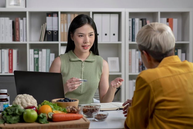 Nutritionist with woman client talking about meal plan and healthy products during a medical consultation in the office