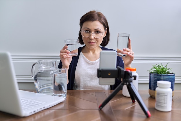 Donna nutrizionista che parla online di vitamine per l'acqua mangiate in modo sano