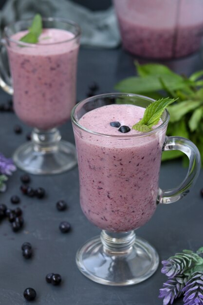 Nutritious cocktail with yogurt and blueberries located in glasses on dark