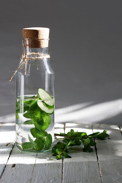 Nutriente acqua detox o emonade con cetriolo e menta su tavola di legno