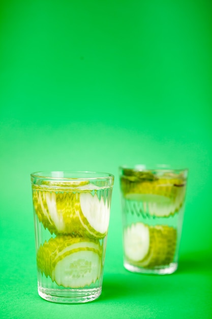 녹색 배경에 유리잔에 담긴 유기농 오이로 만든 영양가 있는 신선한 홈메이드 디톡스 물