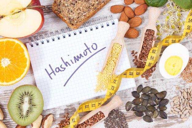 Photo nutritious ingredients and inscription hashimoto written in notepad healthy food containing vitamins problems with thyroid concept