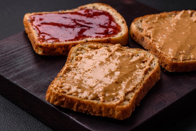 Фото Питательные бутерброды, состоящие из хлеба, малинового варенья и арахисового масла.