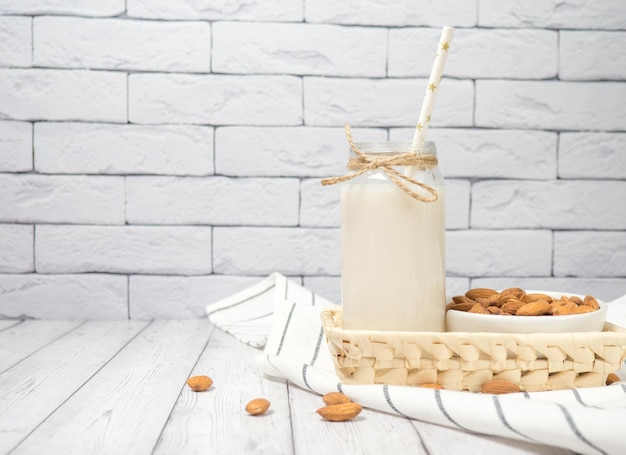 Nuts almonds and almond milk on a white wooden table