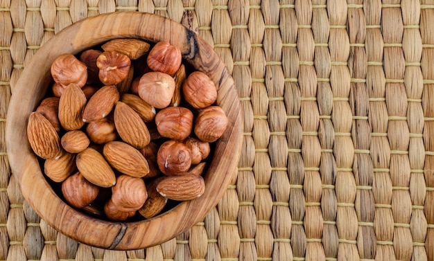 Nuts in assortment in wooden dishes top view with a place to copy.