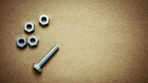 Photo nuts and bolts on abandoned paper. - for diy or construction concept background.