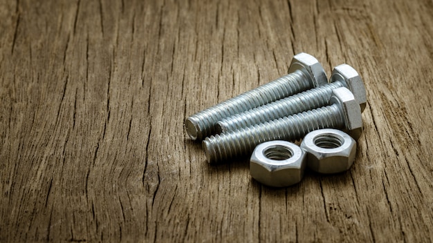 Nuts and bolts on abandoned wood desk.