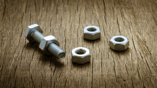 Nuts and bolts on abandoned wood desk.