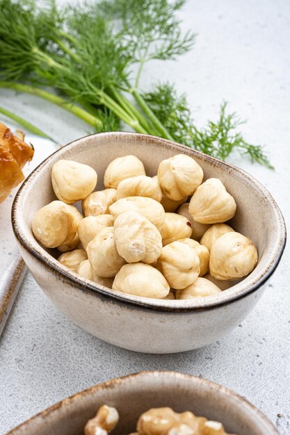 Nuts in bowl on white stone table background