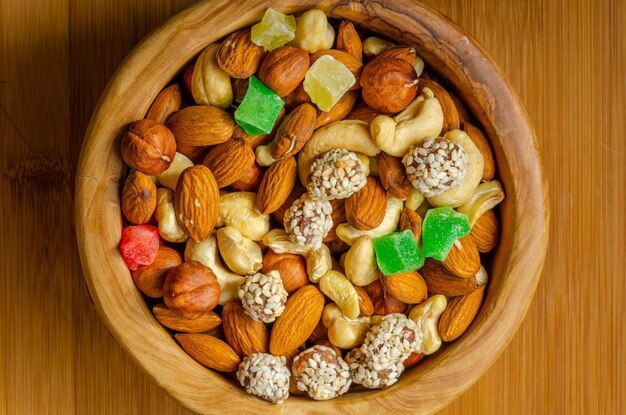 Nuts and candied fruits in a wooden plate.view from above