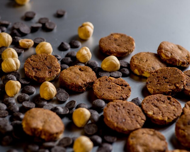 Nuts cookies and chocolate drops on a gray background Copy space