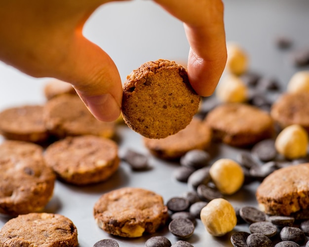 Foto biscotti alla frutta secca e gocce di cioccolato su sfondo grigio copia spazio