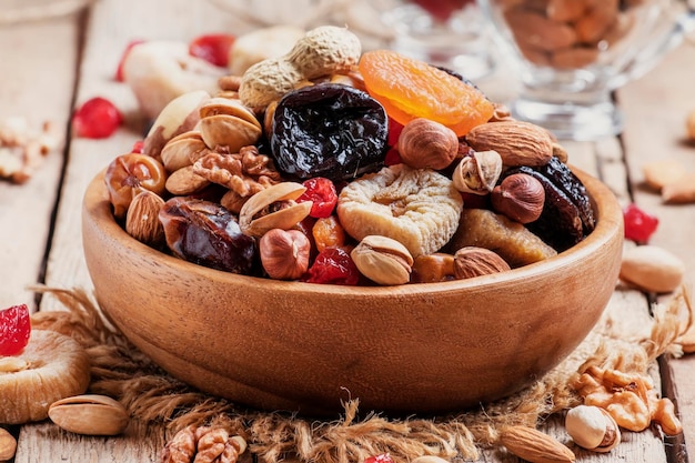 Nuts and dried fruit mix healthy and wholesome food Vintage wooden background selective focus