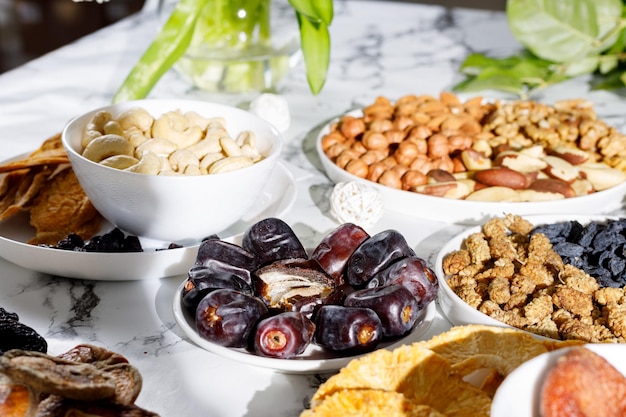 nuts dried fruits and dates are on the table in the sun