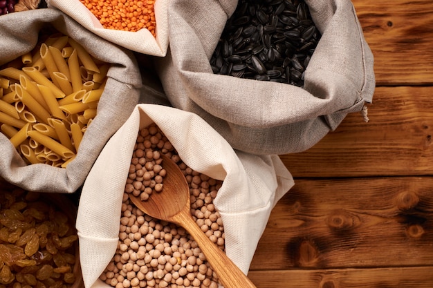 Nuts, dried fruits, and vegetables in eco-cotton bags on the wooden table